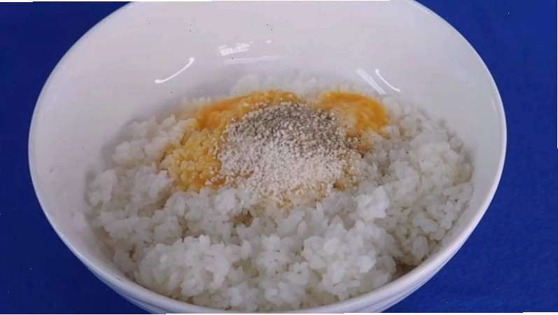Trộn đều cơm nguội với lòng đỏ trứng và gia vị